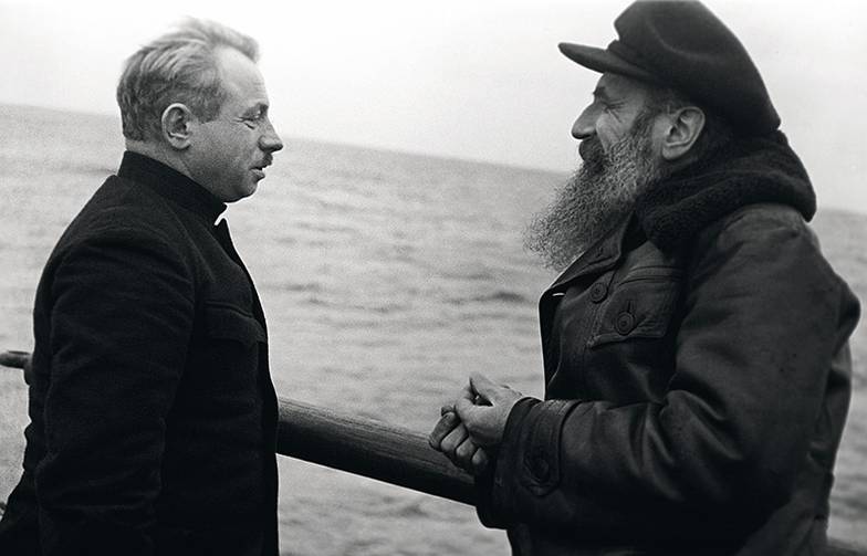 ТАСС Март 1938 г. Начальник дрейфующей станции «Северный полюс — 1» Иван Дмитриевич Папанин и Герой Советского Союза, действительный член Академии наук СССР,  начальник Главного управления Северного морского пути Отто Юльевич Шмидт (слева направо) на ледоколе «Ермак». Точная дата и место съемки не установлены