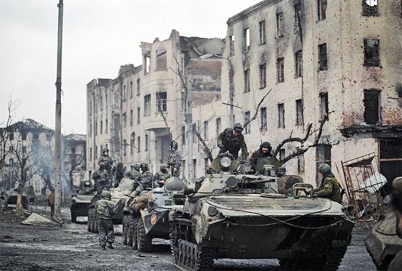 ХАМЕЛЬЯНИН ГЕННАДИИ/ФОТОХРОНИКА ТАСС Война в Чечне, февраль 1995 года. Солдаты внутренних войск на улице Грозного