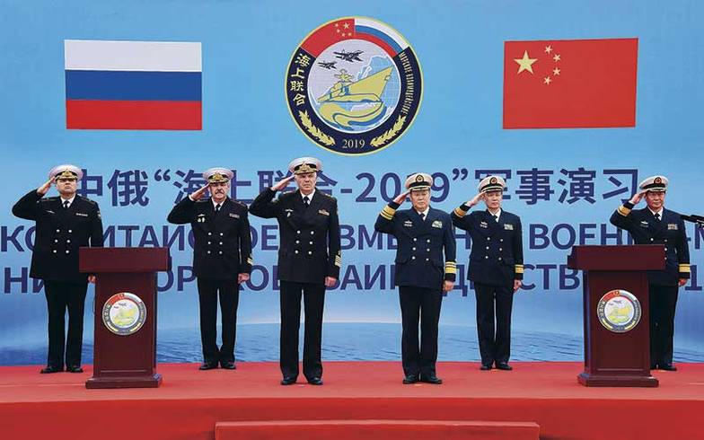 XINHUA VIA ZUMA WIRE Заместитель главнокомандующего Военно-морским флотом России Александр Витко и вице-адмирал Военно-морских сил Китая Цю Яньпэн (слева направо на первом плане) во время официальной церемонии открытия совместных военно-морских учениях Китая и России «Морское взаимодействие — 2019»