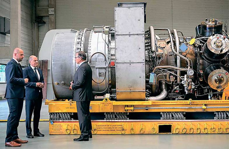 EPA/SASCHA STEINBACH/ТАСС Канцлер ФРГ Олаф Шольц (второй слева) осматривает турбину Siemens для компрессорной станции «Портовая» газопровода «Северный поток»